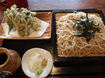 右側にざる蕎麦　左側に春野菜の天婦羅　手前に薬味　薬味は山葵、ねぎ、ゴマ